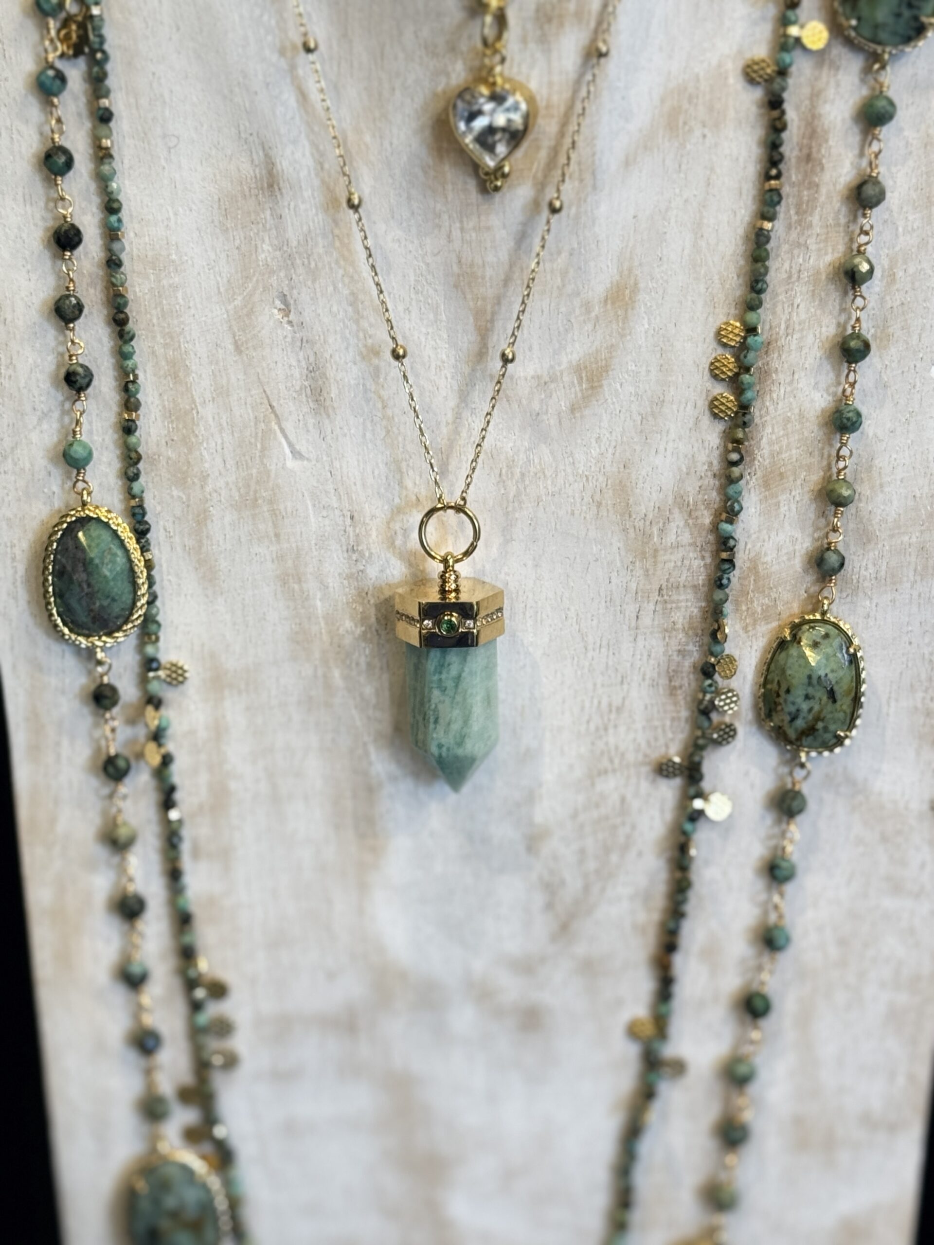 “Collection de 4 colliers : 2 sautoirs en turquoise africaine, 1 pendentif Zag avec amulette, 1 collier cœur zirconium brillant.”