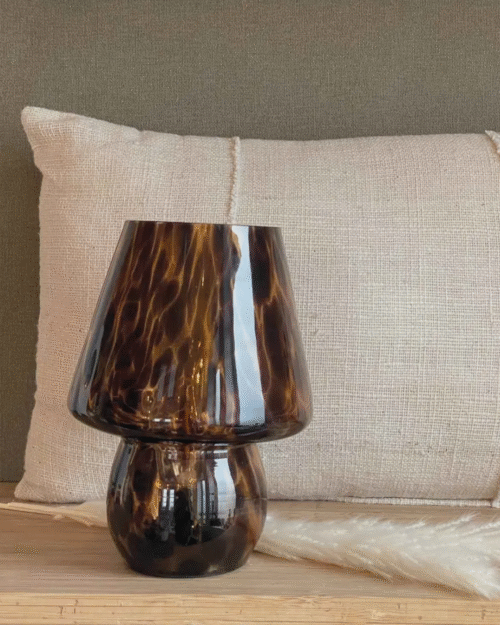 Lampe décorative en verre léopard sans fil posée sur une table en bois