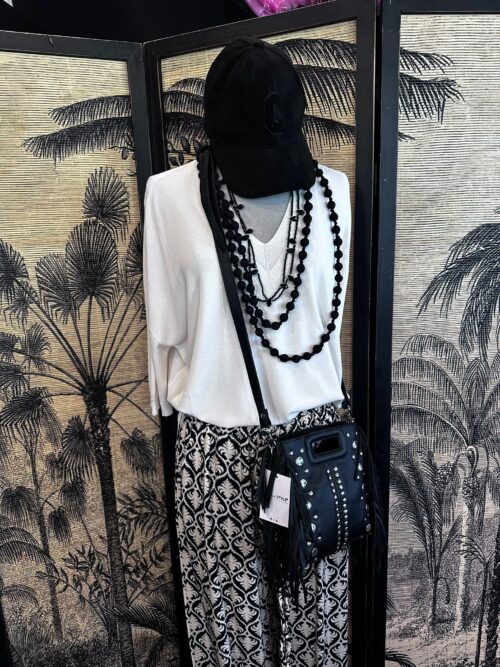 Look noir graphique avec maille crème et accessoires noirs vibrants